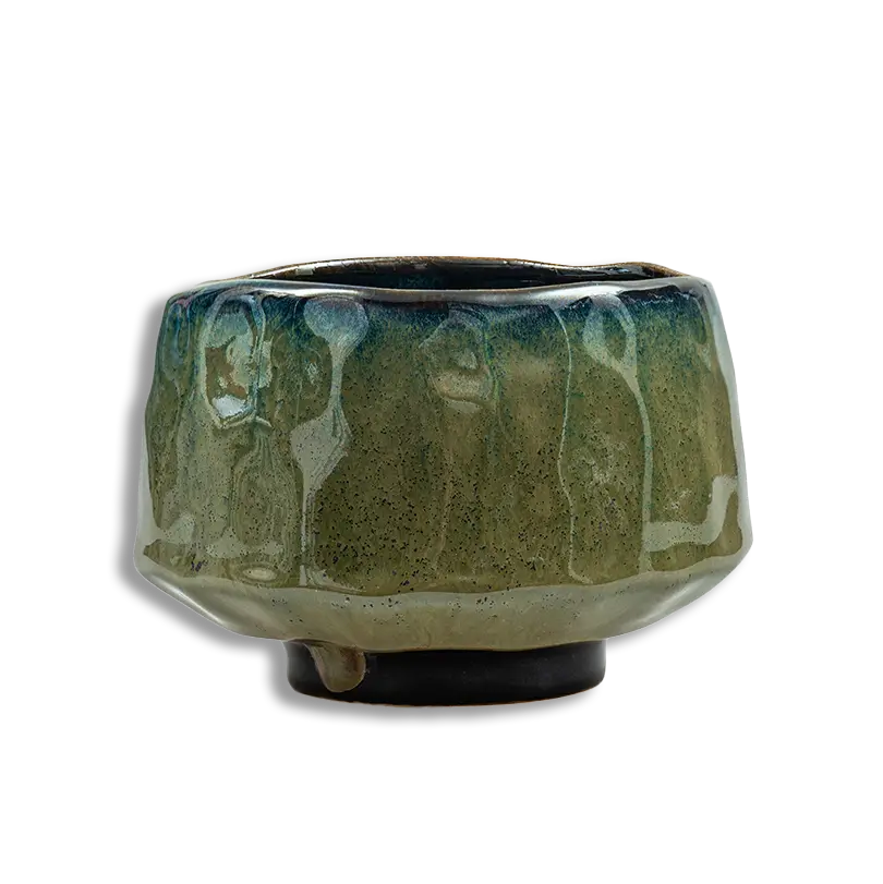 Green ceramic pot with textured surface on a white background