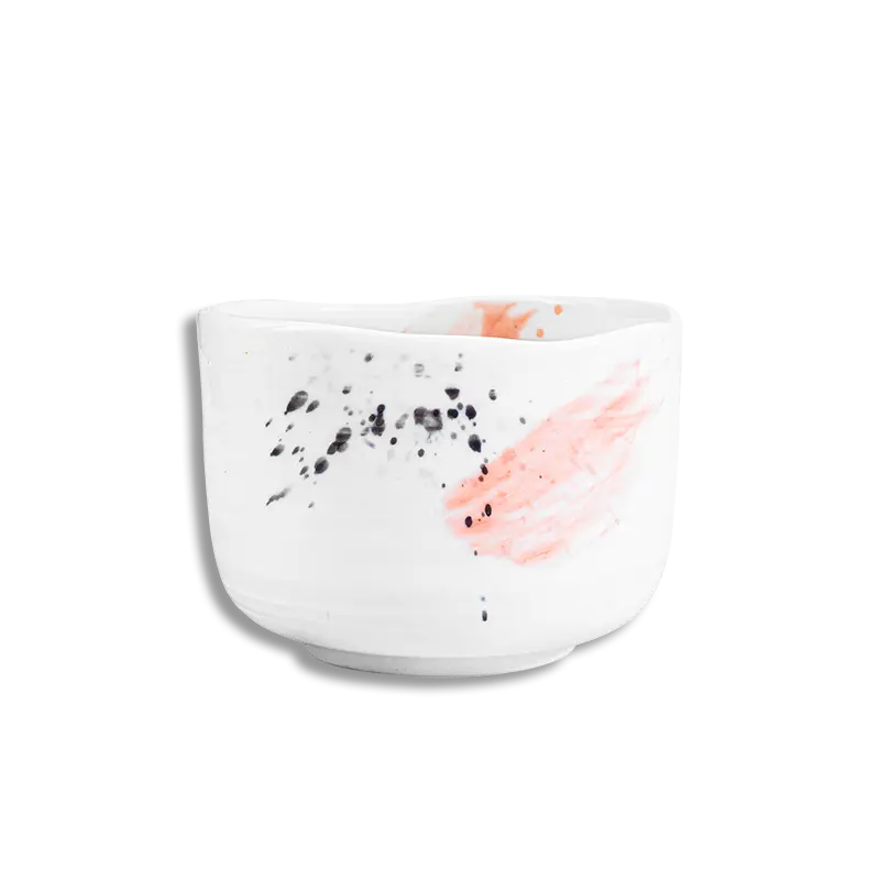 White ceramic bowl with black speckles and pink abstract design on a white background