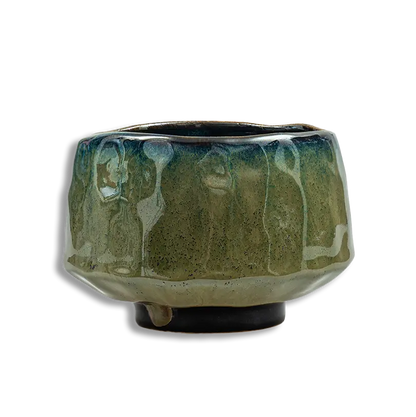 Green ceramic pot with textured surface on a white background